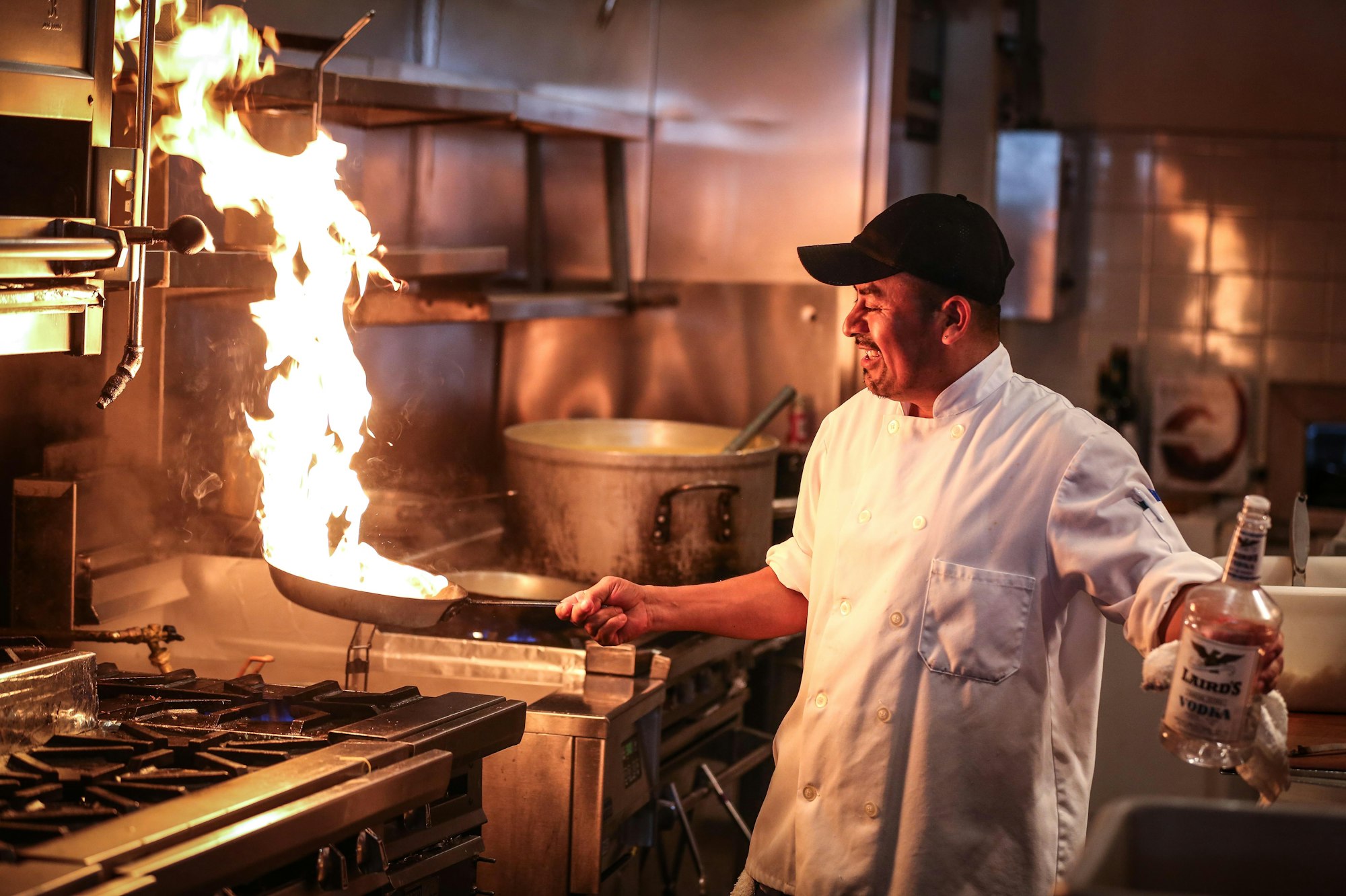 Le chef saisit une poêle dans une haute flamme en cuisine
