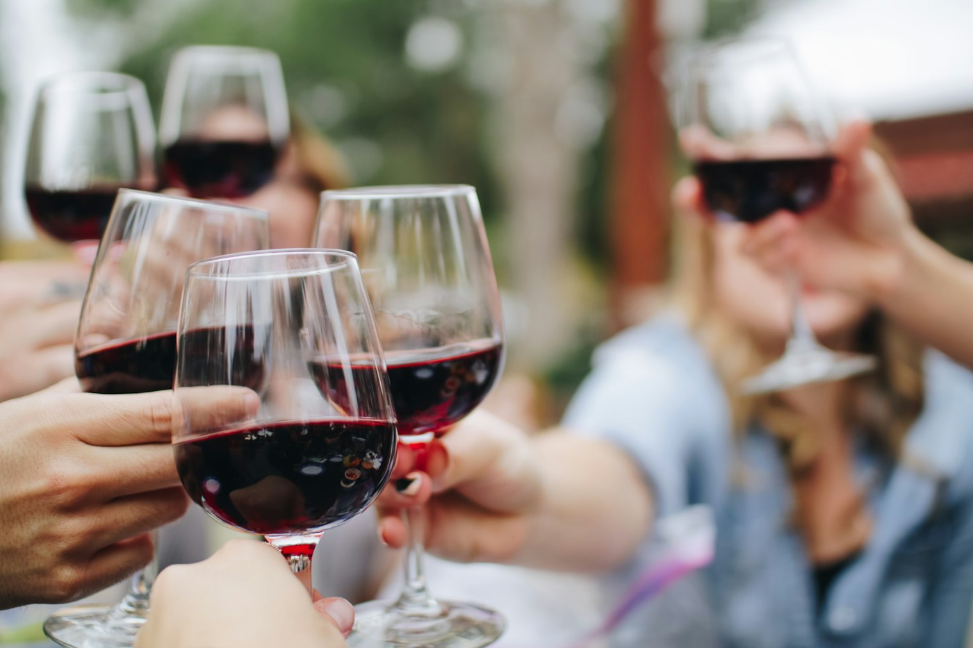 Des amis trinquent avec des verres de vin rouge
